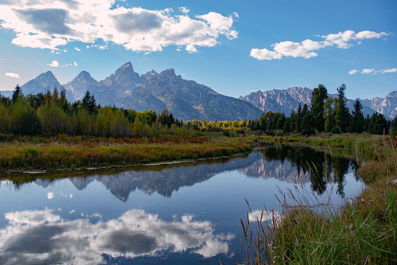 Water of the Snake River mirroring the teton mountains in early fall