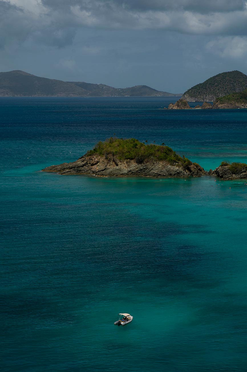 Small boat floating in the rich blue waters of Trunk Bay off of St. John in the US Virgin Islands