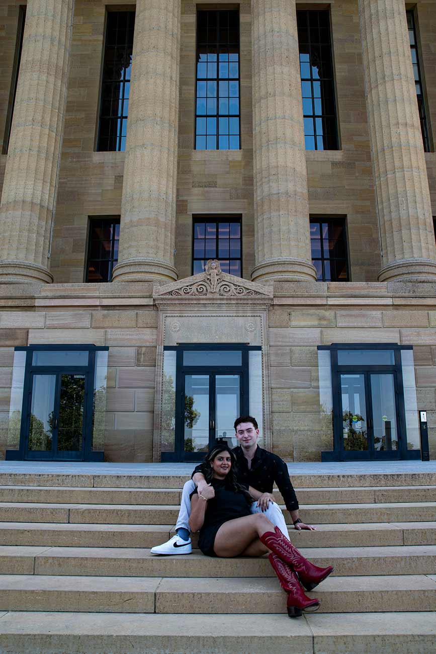 Medha and Will sitting together on the steps of the Philadelphia Art Museum