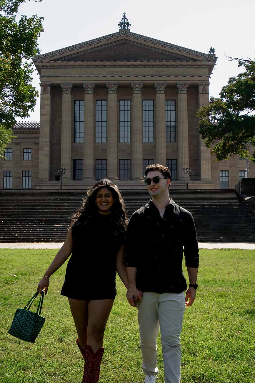 Medha and Will walking towards the camera with the Philadelphia Art Museum in the background